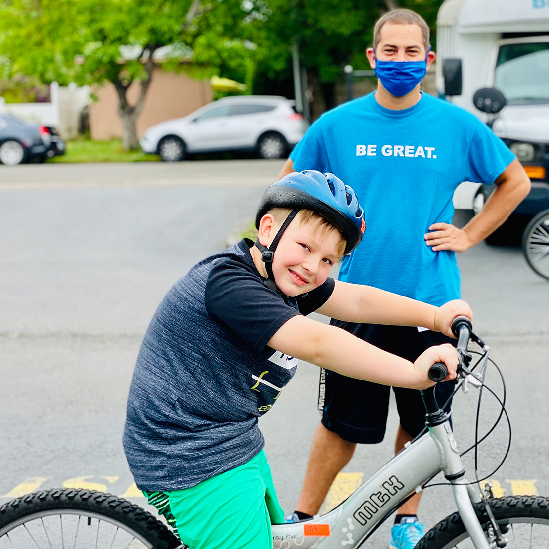 Refer a Friend and Help the Boys & Girls Club in Your Community_volunteer and boy on bike
