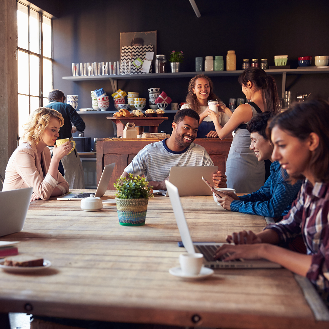 Group of people sitting in a Cafe using the businesses WIFI