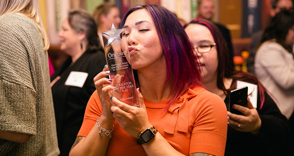 Tori Sharpe kissing 2019 OnPoint Prize for Excellence in Education award