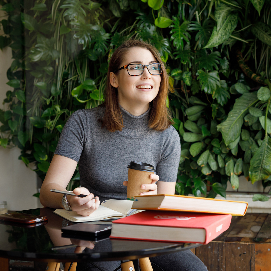 college student studying and smiling while looking out the window
