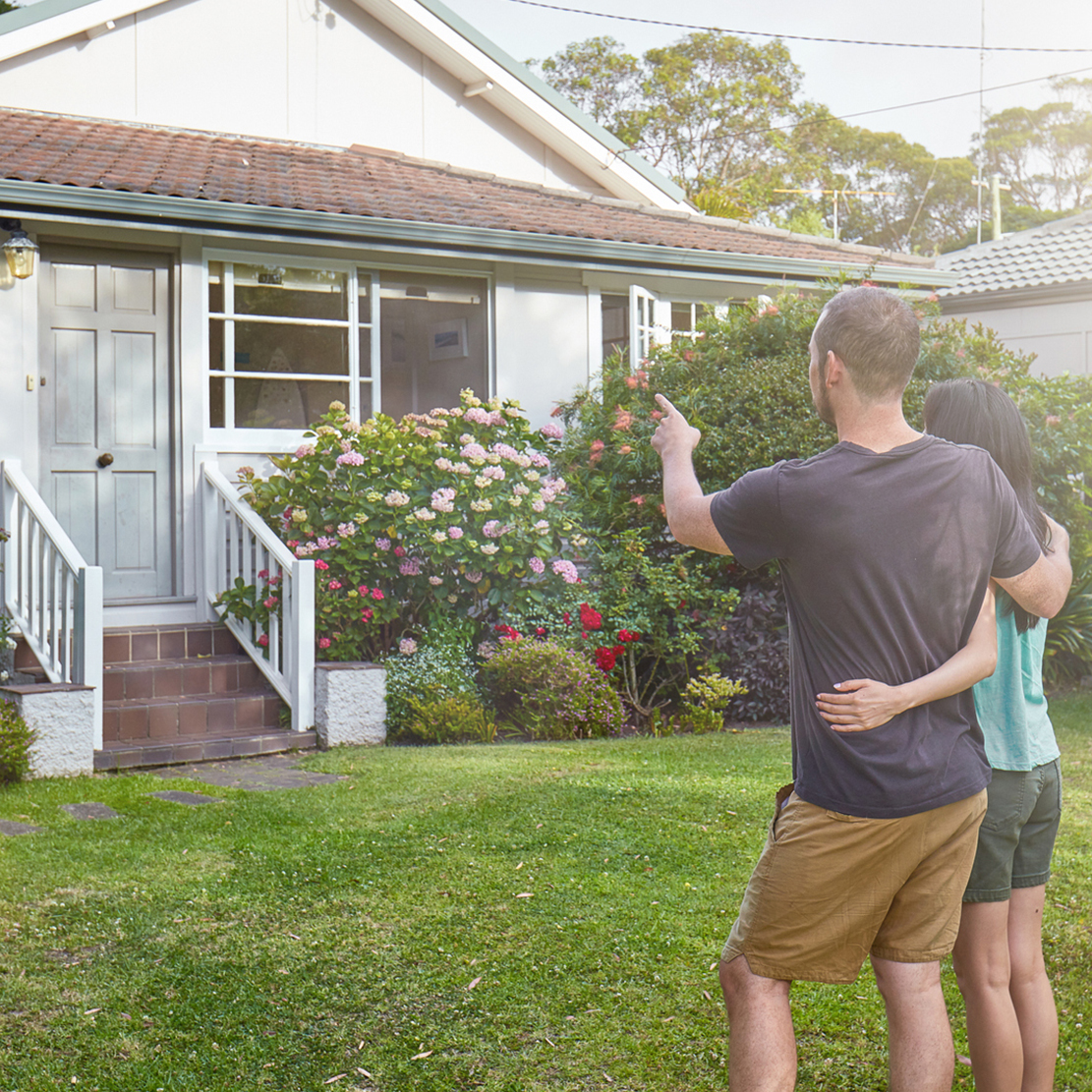couple standing outside a house that they are interested in buying