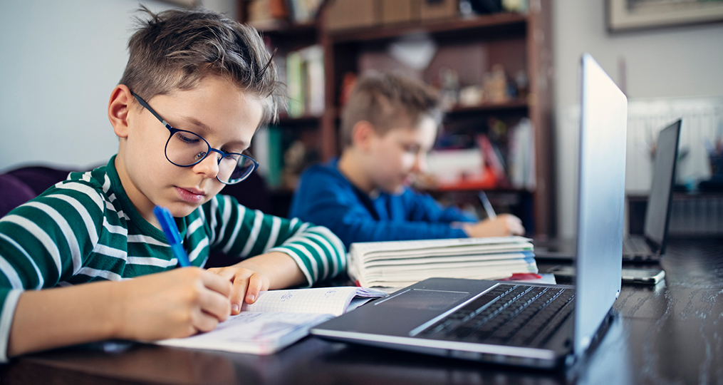 keeping kids connected to class_two boys writing and studying at home at the kitchen table