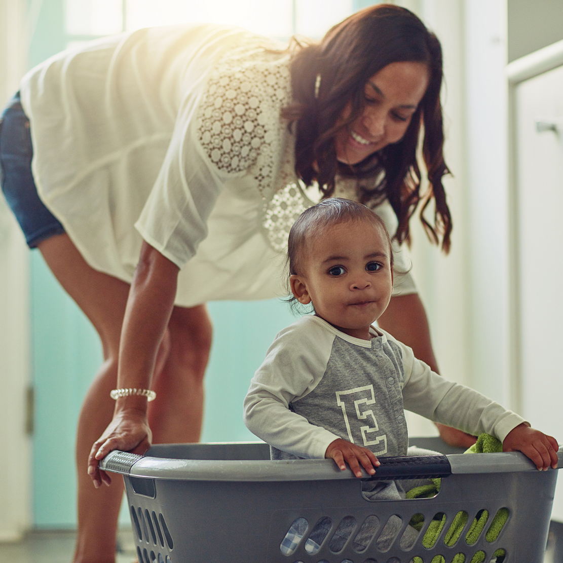 mother pushing around her baby in a laundry basket