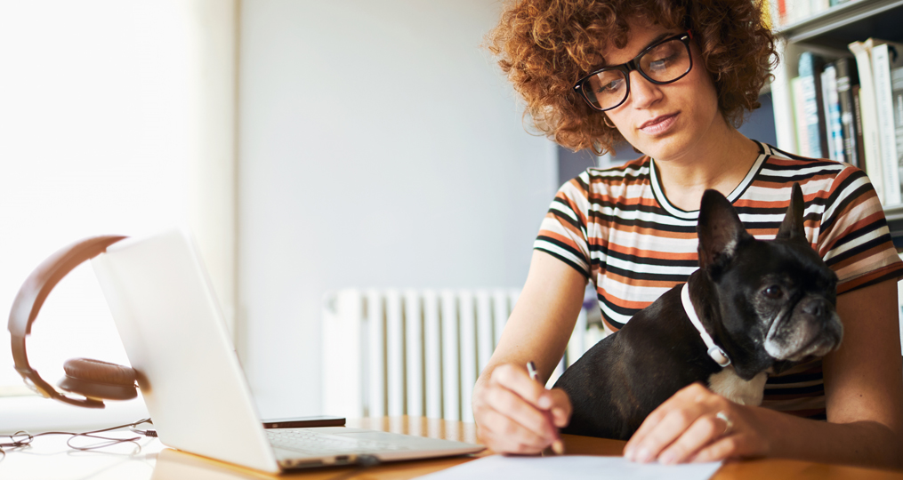 what budgeting method is right for you_woman sitting at desk taking notes with dog in her lap