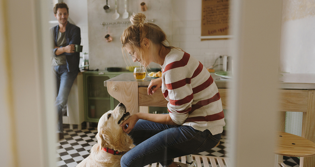 what young adults need to know about generational changes in spending habits_young woman smiling while petting her dog