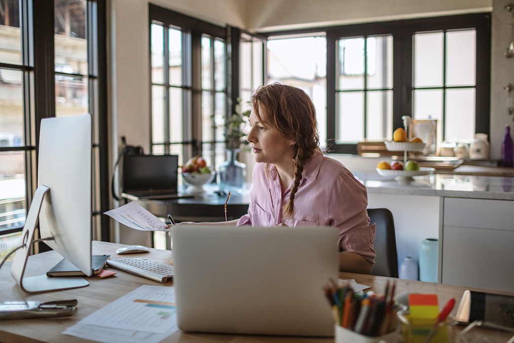 Building a Legacy of Financial Literacy_Woman looking through personal finances in her kitchen