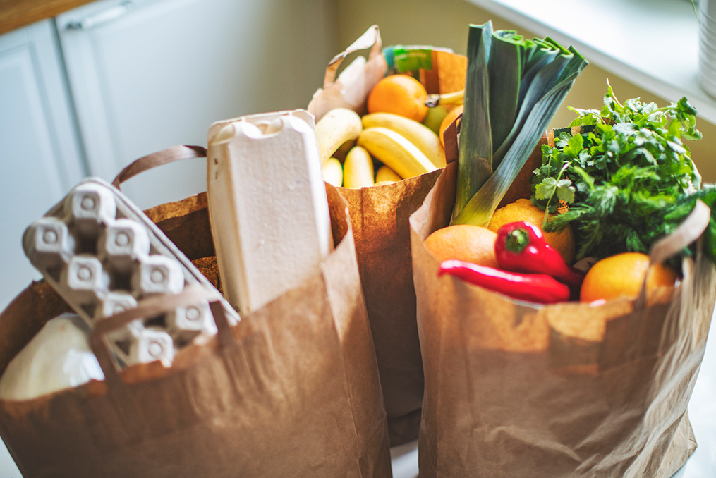 15 Easy Ways to Save Money on Groceries_three bags of groceries on kitchen table