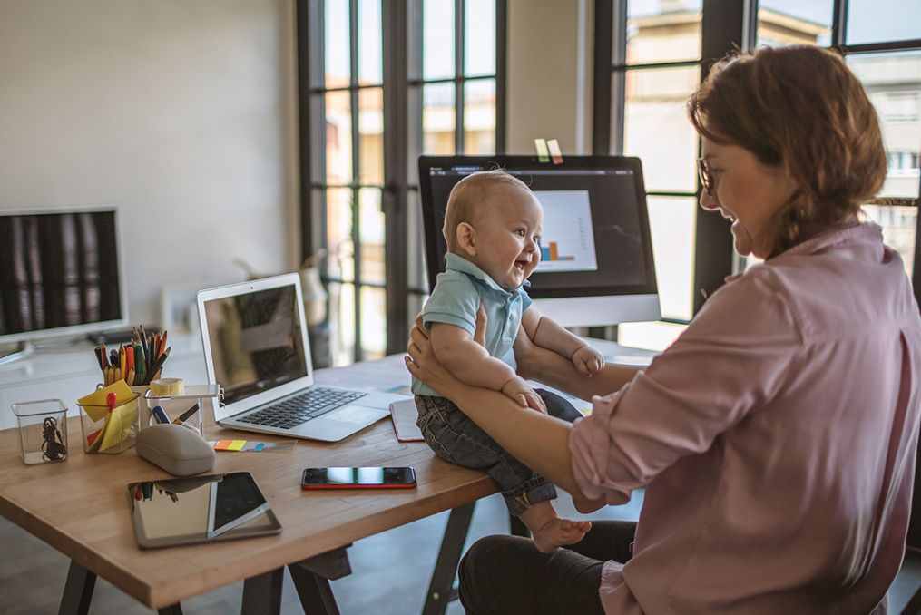 Building a Legacy of Financial Literacy_mom smiling at baby boy while working on family finances
