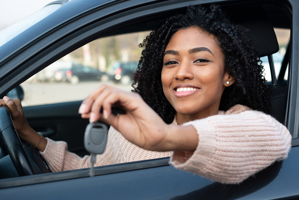 How to Spot Red Flags When Buying and Selling Vehicles_young woman holding the keys to her new car