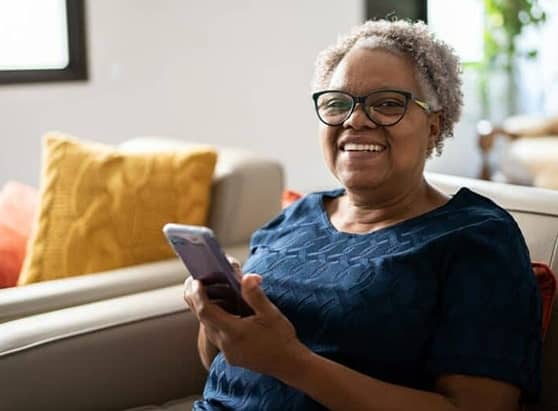 How-to-cancel-auto-renewal-on-subscriptions_older-woman-sitting-down-looking-at-her-phone