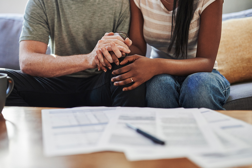 The difference between good and bad debt_Man and woman holding hands and reviewing documents