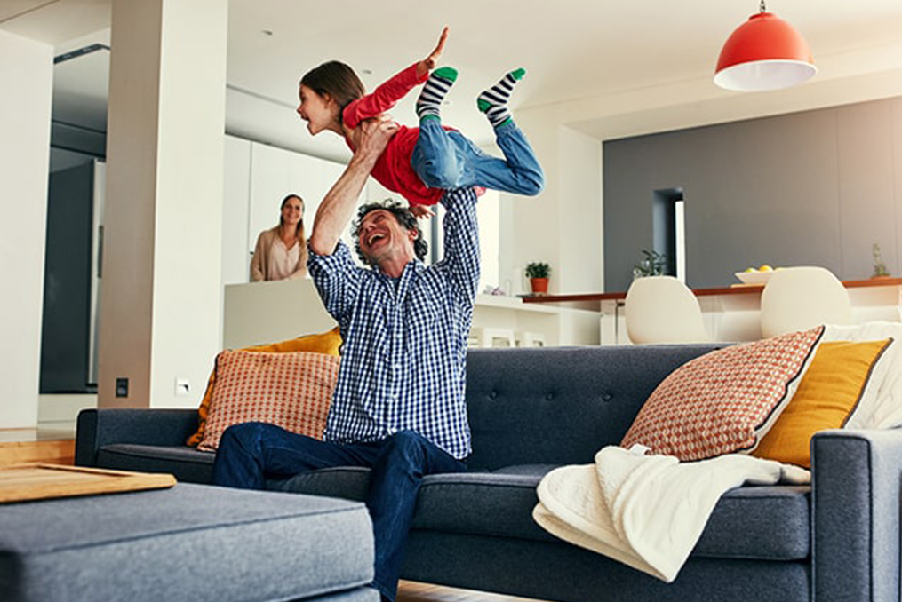 father holding his child in their living room