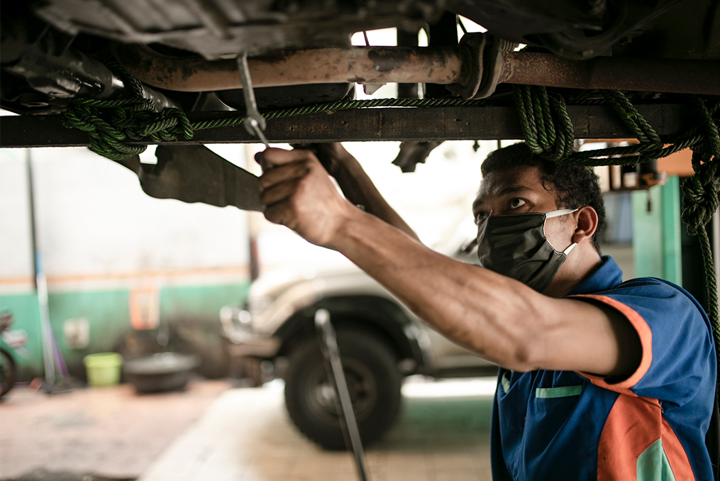 how to safely buy a used car_Mechanic inspecting vehicle on a lift