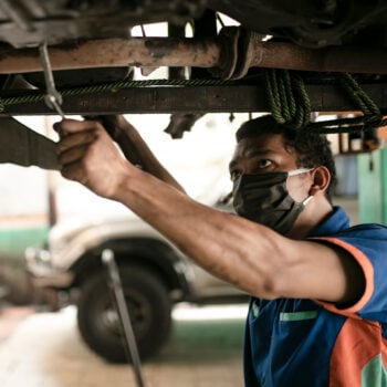 how to safely buy a used car_Mechanic inspecting vehicle on a lift