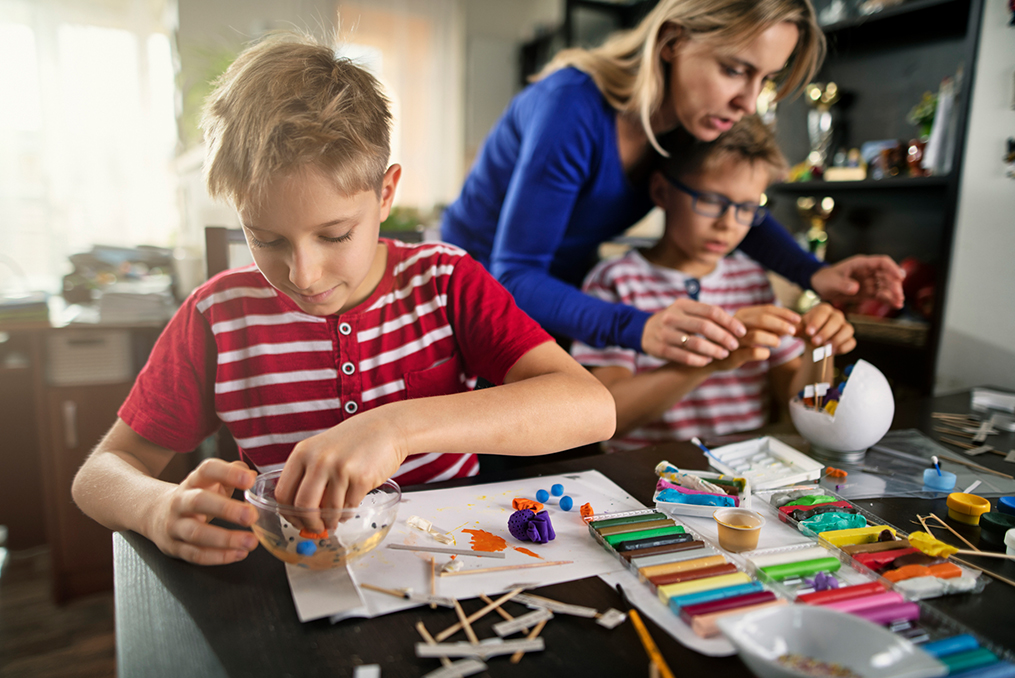 keeping kids connected to class_mom helping her two boys with an at home science project