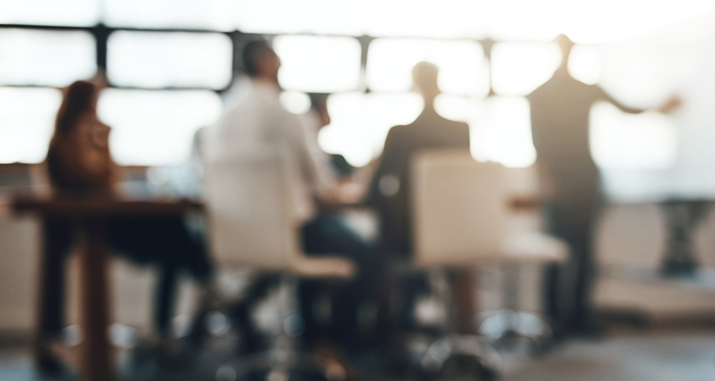 out of focus view of a meeting in a board room