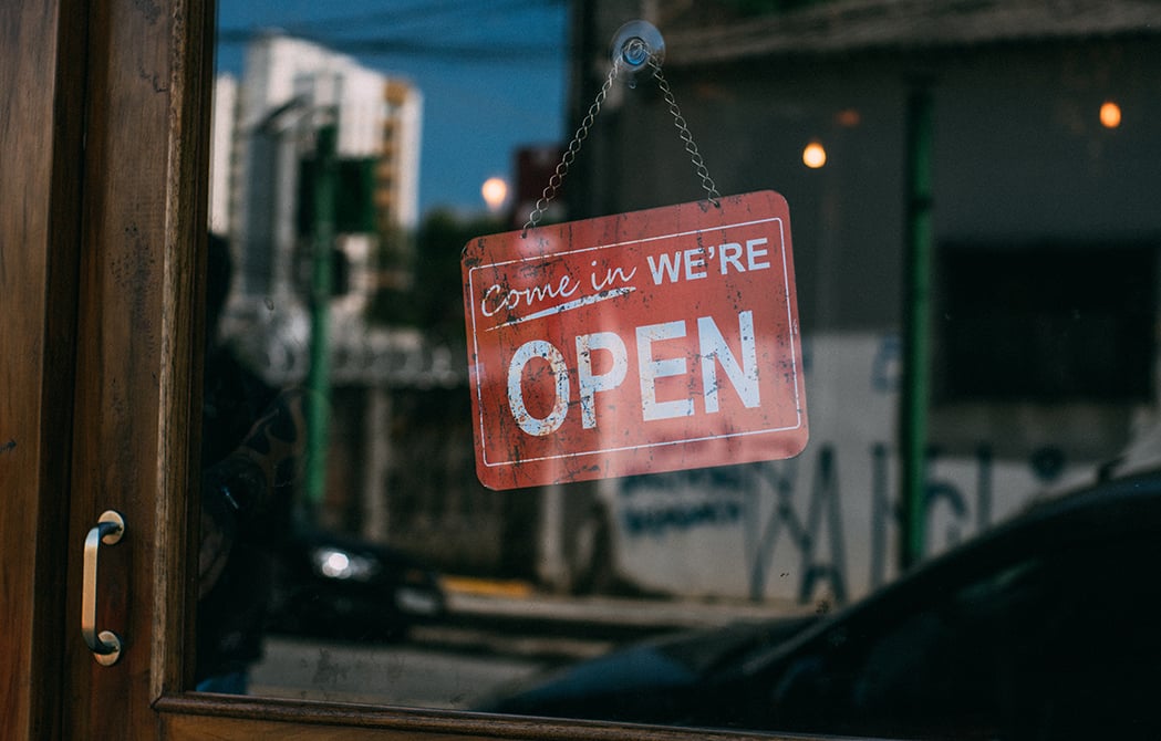 Come in we're open sign in window of door at entrance to business.