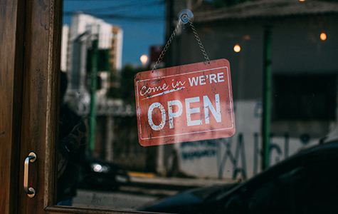 Come in we're open sign in window of door at entrance to business.