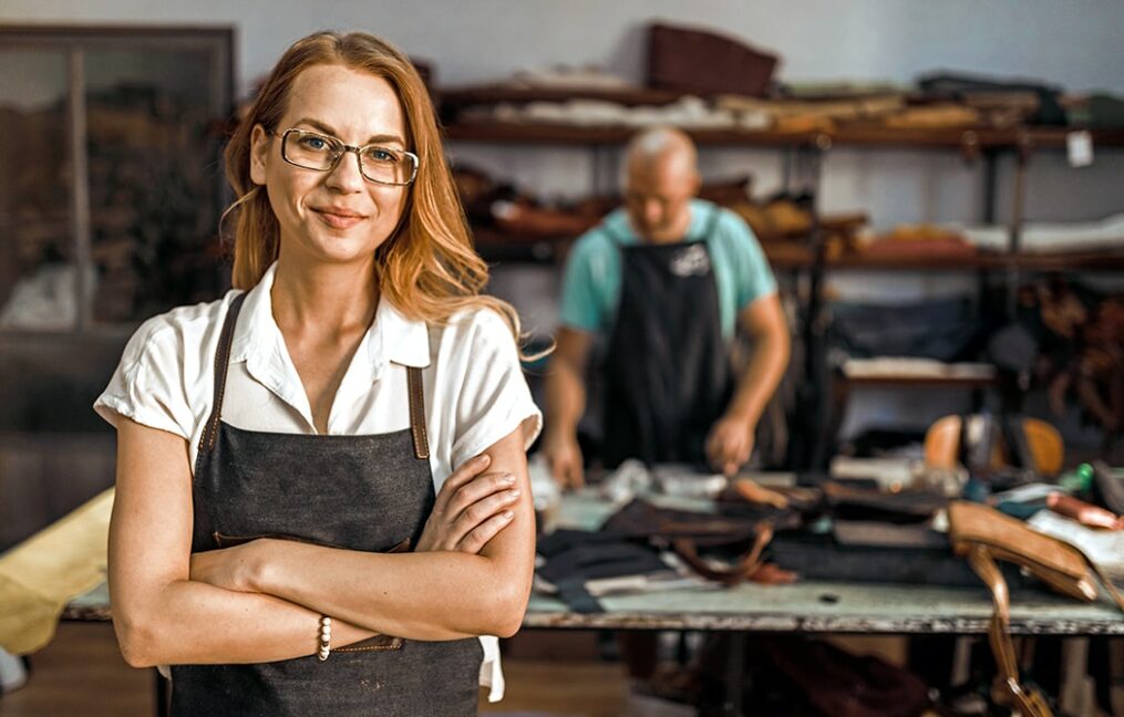 Business Credit Card Landing Page-woman business owner feeling confident while working in the leather shop