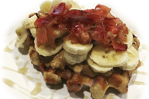 Image of waffle topped with bananas and bacon from Syrup Trap