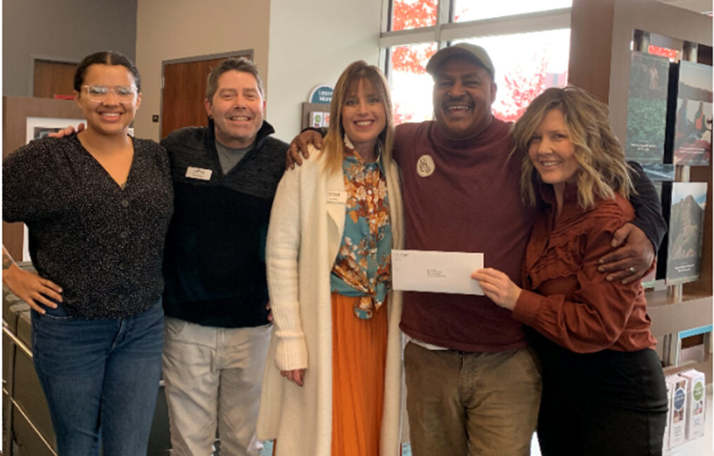 Group of OnPoint employees holding a check