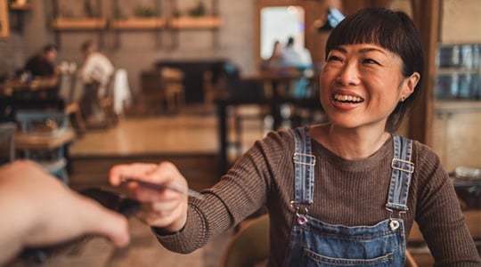 women using tap to pay at resturant onpoint checking accounts