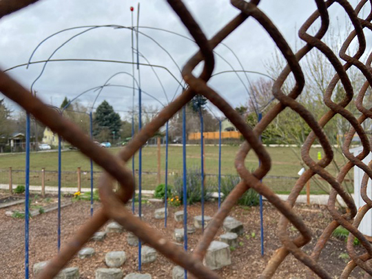 Track and field grounds at Grout Elemetary School, shown through a cyclone fence