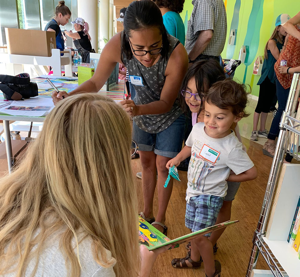 Volunteers of Babies with Books share books with young toddlers