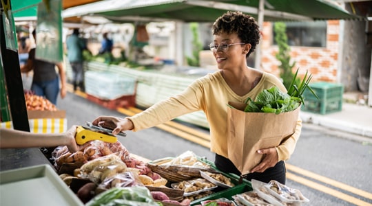 woman paying for groceries at farmers market