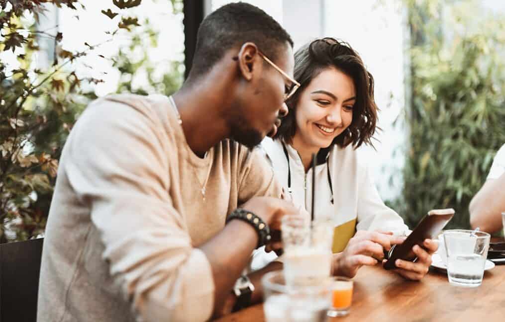 Couple looking at phone together at restaurant