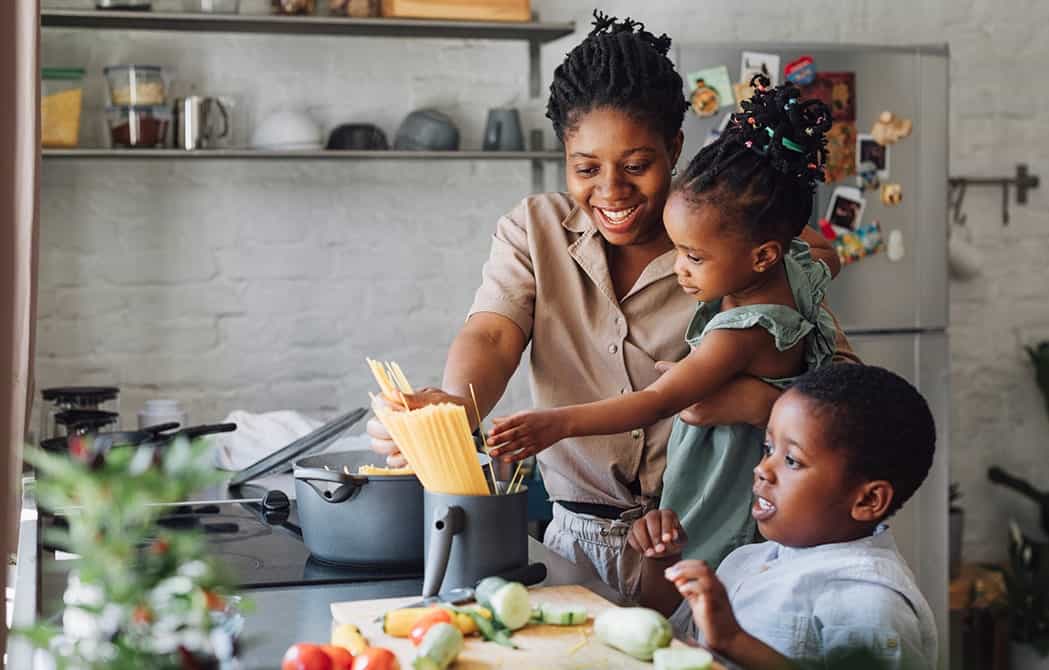 Mom cooking dinner with her kids