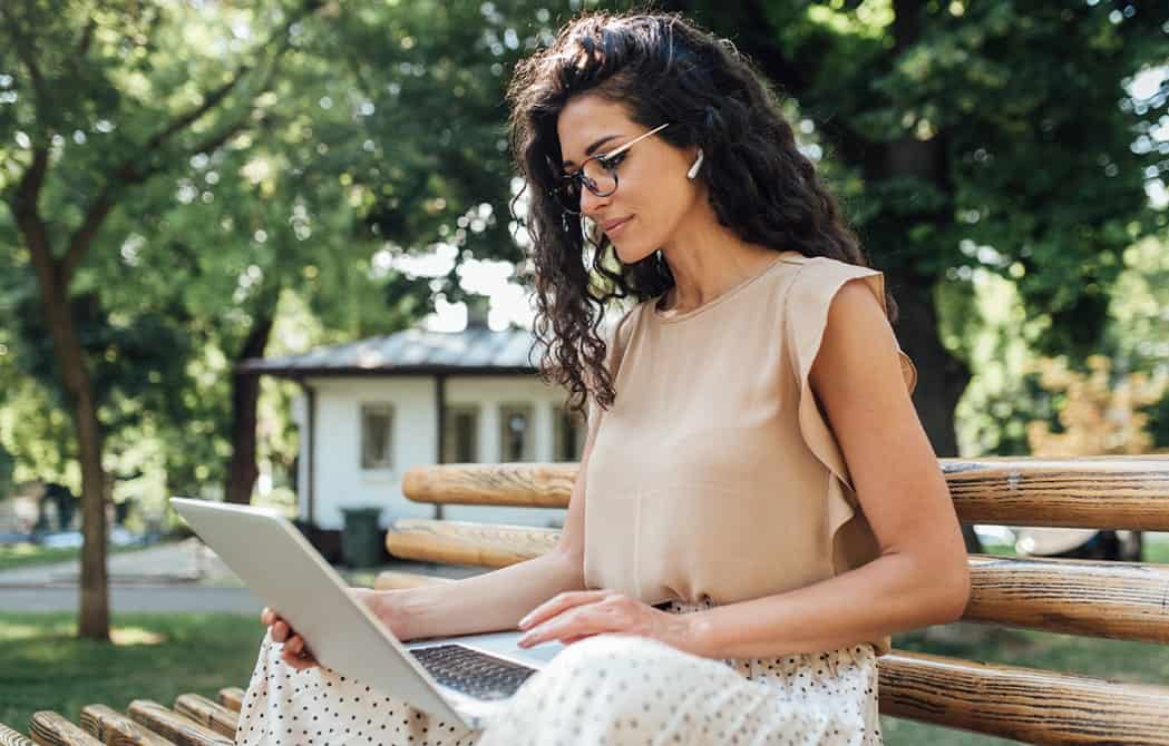 Woman-looking-at-laptop_outside