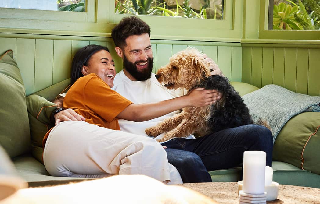 couple-hugging-with-dog-on-couch_