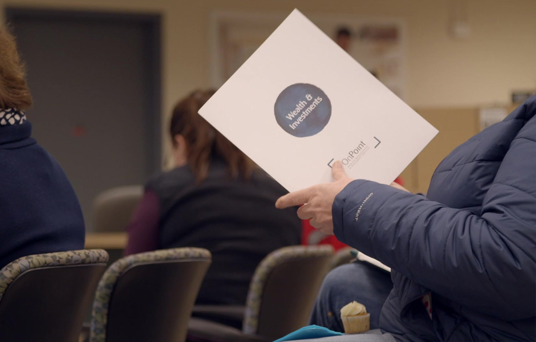 seminar attendee holding OnPoint investments folder