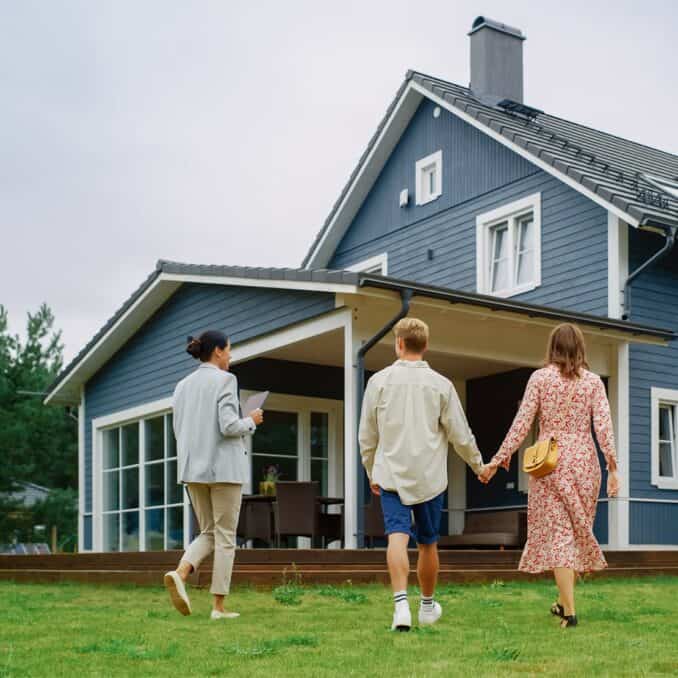 couple-looking-at-a-house-with-agent