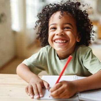 boy-smiling-sitting-in-desk