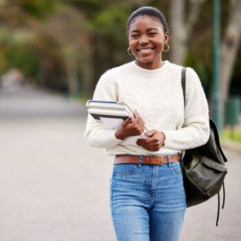 Girl standing outside with text books