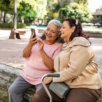 two-senior-Hispanic-women-using-mobile-phone