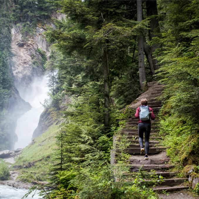person-hiking-next-to-waterfall