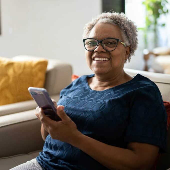 older-woman-sitting-down-looking-at-her-phone