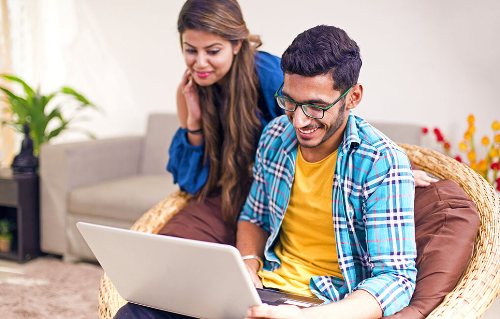 husband and wife looking on laptop for financial counseling at home