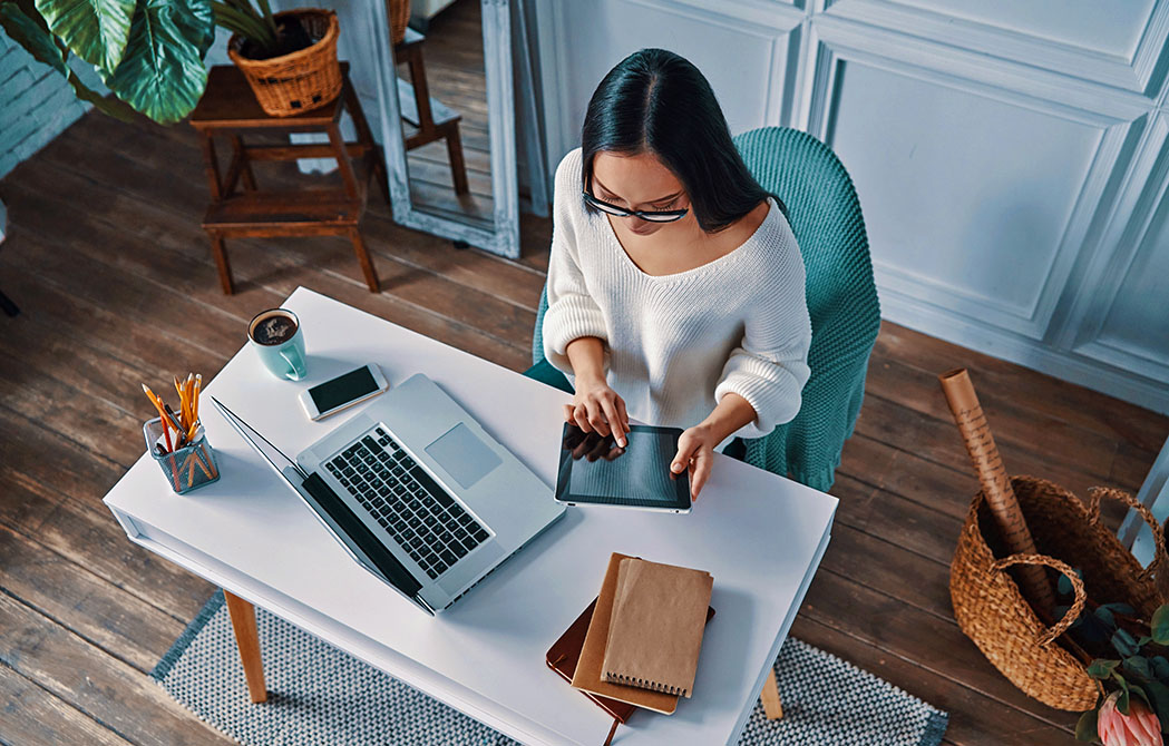 Overhead view of woman at desk on laptop