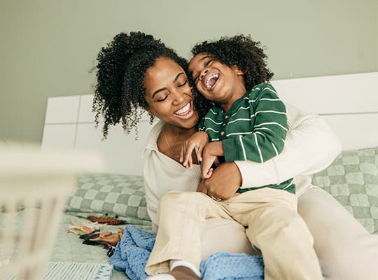 mom and son playing on couch with dinosaurs onpoint financial education