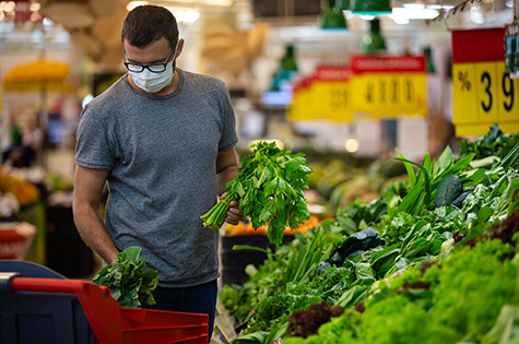 male wears mask against coronavirus while grocery shopping