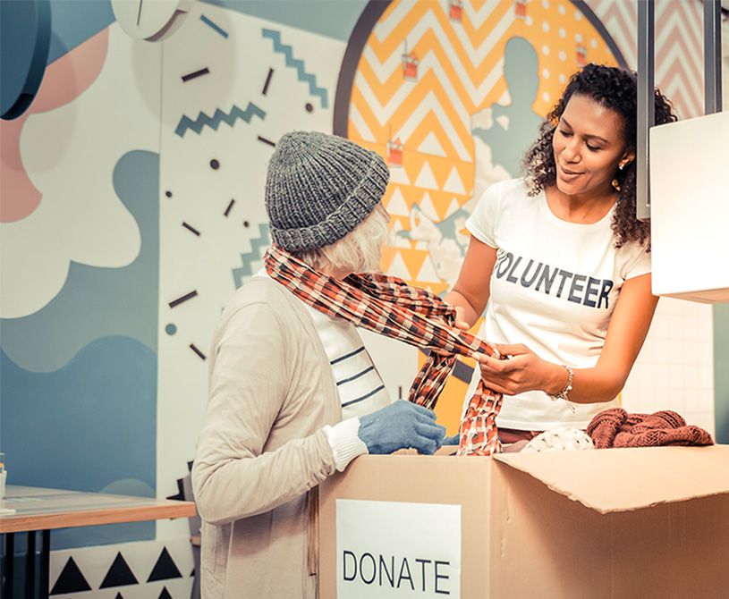 Volunteer providing scarf out of a donation box