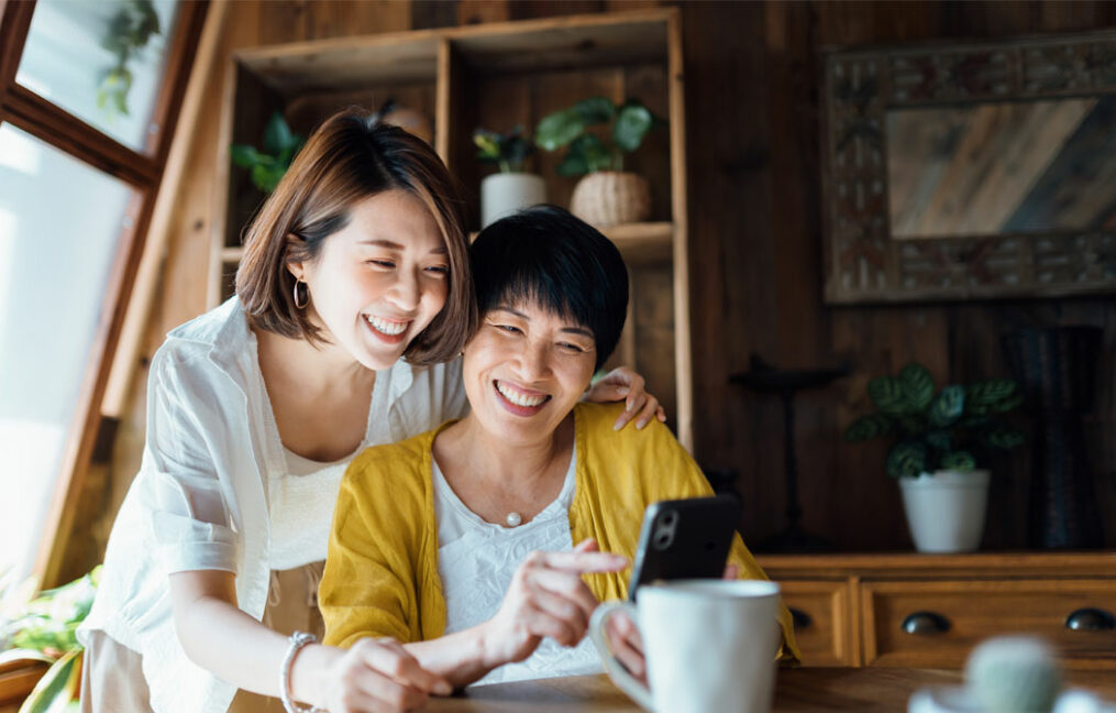 Premium Bundle Rewards Savings - two women using a phone - many potted house plants in background