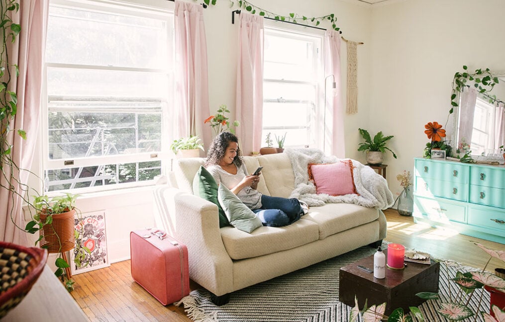 woman-on-couch-in-home-looking-at-mobile-phone