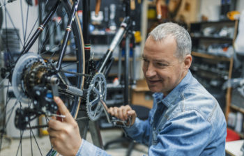 Retirement Services and Planning_mature man working on a bicycle