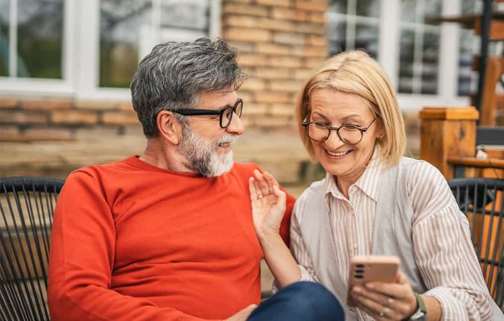older couple sitting looking at phone onpoint innovest
