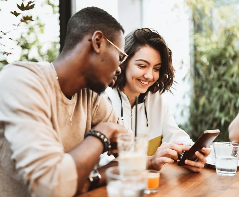 Couple looking at phone together at restaurant